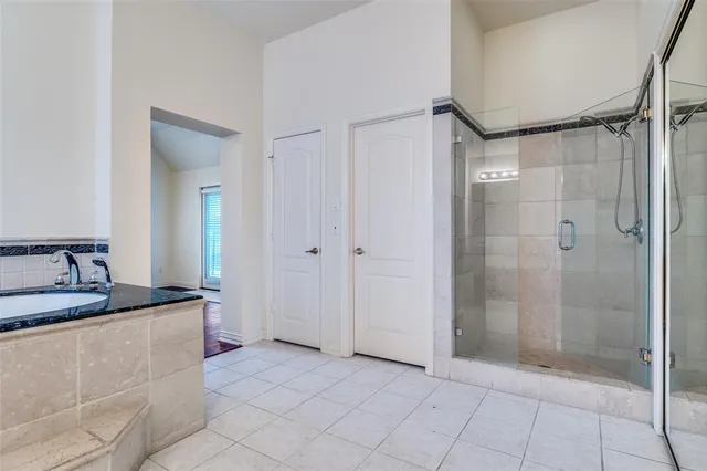 a bathroom with a granite countertop sink and a bathtub