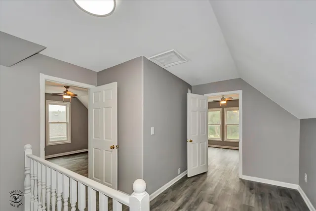 a view of a hallway with wooden floor and closet
