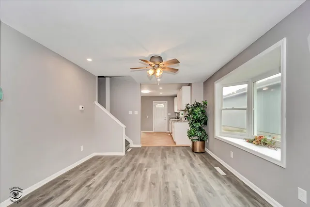 a view of an empty room and window and wooden floor