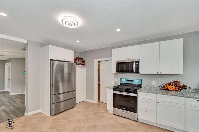 a kitchen with stainless steel appliances granite countertop a refrigerator sink and stove