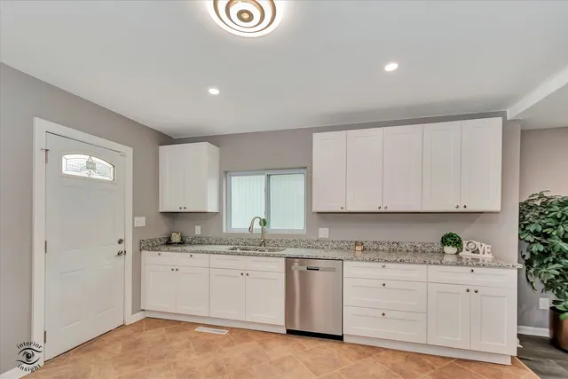 a kitchen with granite countertop white cabinets and white appliances