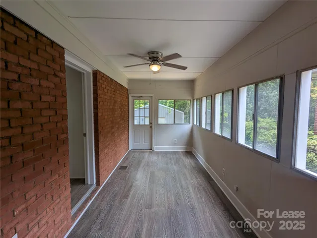 a view of hallway with wooden floor and chandelier