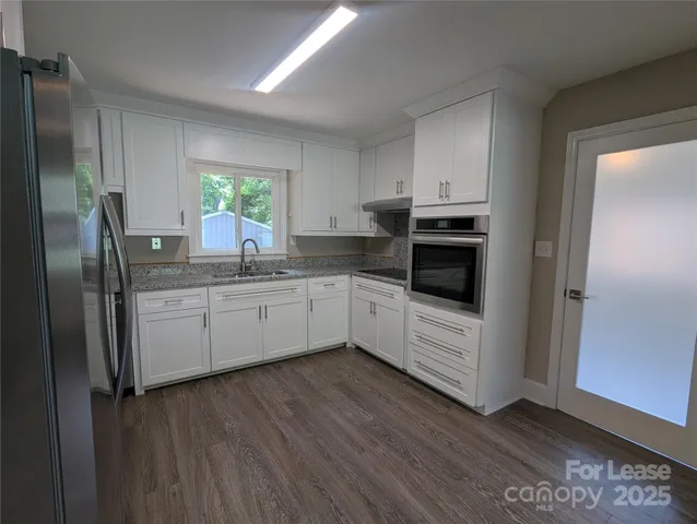 a kitchen with stainless steel appliances a refrigerator sink and microwave