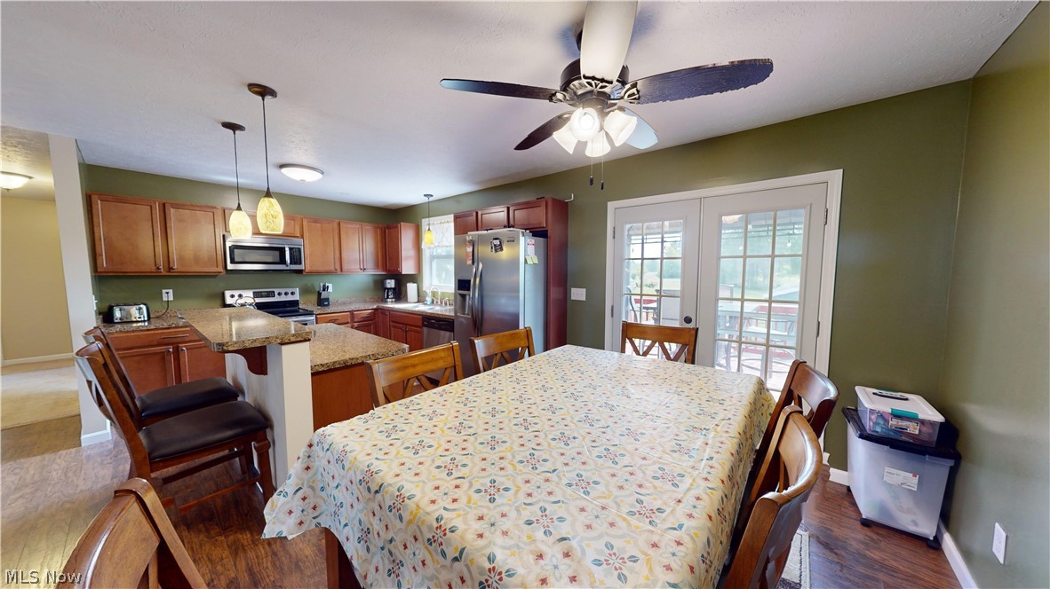 3805 Townline Road Madison, OH 44057 - Photo 14 of 38 Dining space with sink, french doors, ceiling fan, and dark hardwood / wood-style floors