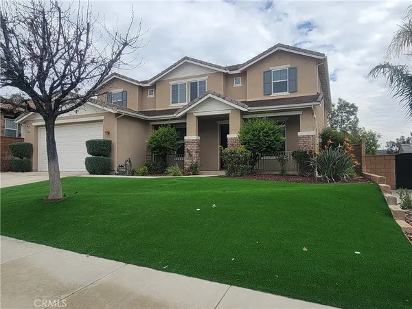 a front view of a house with a garden and plants
