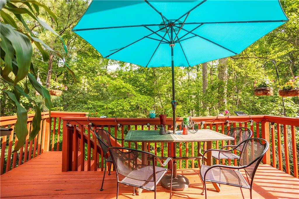a patio with wooden floor a yard a table and chairs