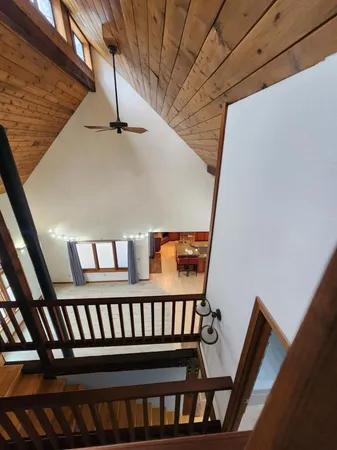 a view of empty room with kitchen and fireplace
