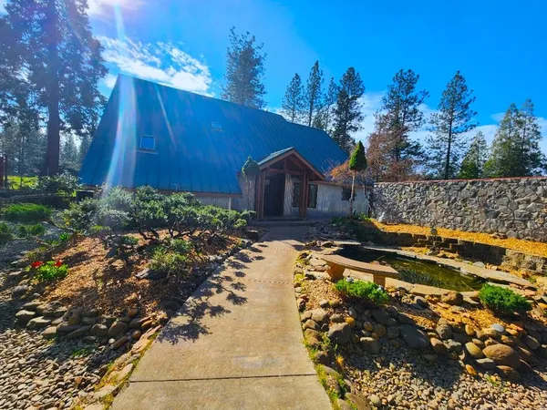 a kitchen with stainless steel appliances granite countertop a stove a refrigerator a sink and a wooden floor