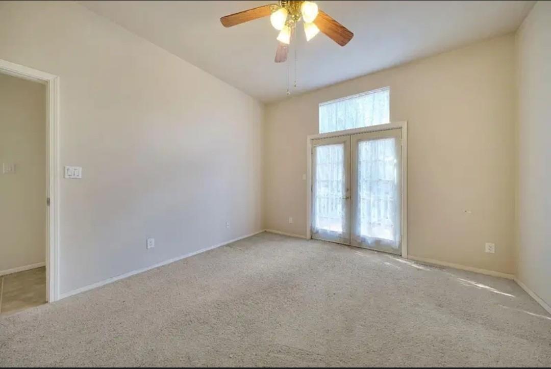 19500 Jesus Maria Road Mokelumne Hill, CA 95245 - Photo 81 of 92 an empty room with a chandelier fan and windows