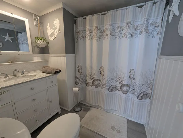 a bathroom with a granite countertop sink toilet a mirror a vanity and shower