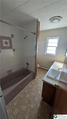 a bath tub sitting in a bathroom next to a window
