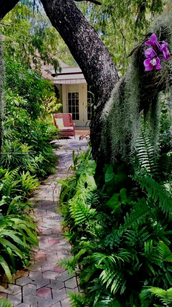 8420 Southwest 70th Street Miami, FL 33143 - Photo 12 of 20 a front view of a house with a yard and potted plants