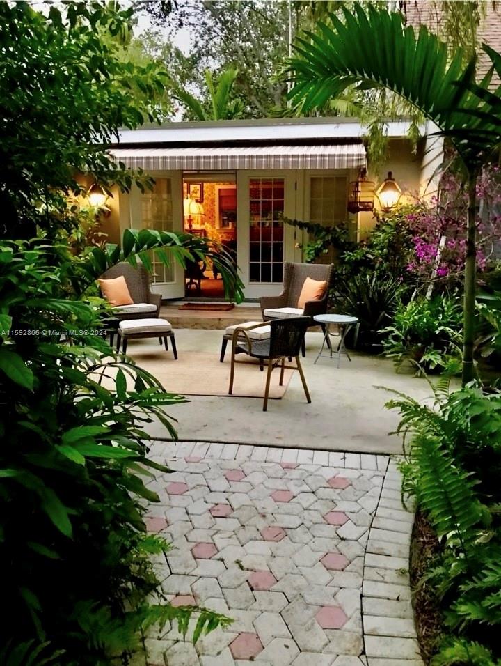 8420 Southwest 70th Street Miami, FL 33143 - Photo 13 of 20 a view of a patio with table and chairs potted plants and large tree