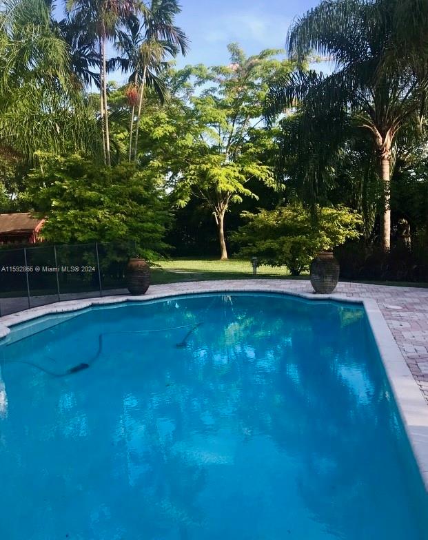 8420 Southwest 70th Street Miami, FL 33143 - Photo 16 of 20 a view of a swimming pool with a yard and large trees
