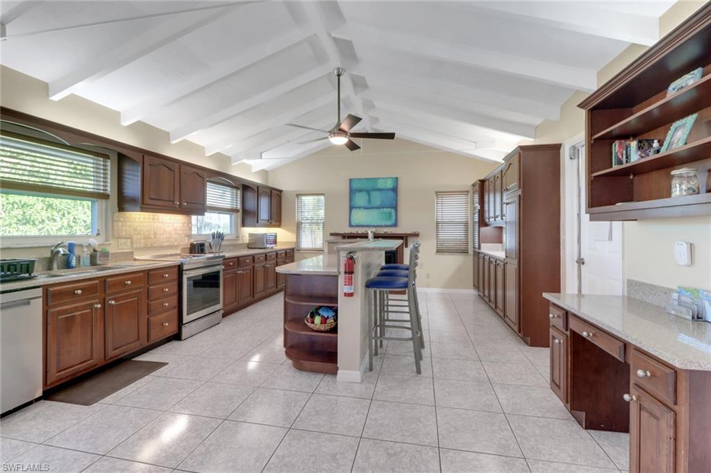 562 Goldcoast Court Marco Island, FL 34145 - Photo 10 of 28 a kitchen with stainless steel appliances granite countertop a table chairs sink and cabinets