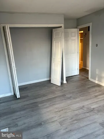 an empty room with wooden floor and closet