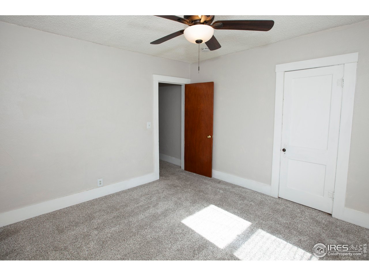 323 Cleveland Street Sterling, CO 80751 - Photo 23 of 28 a view of an empty room with a ceiling fan