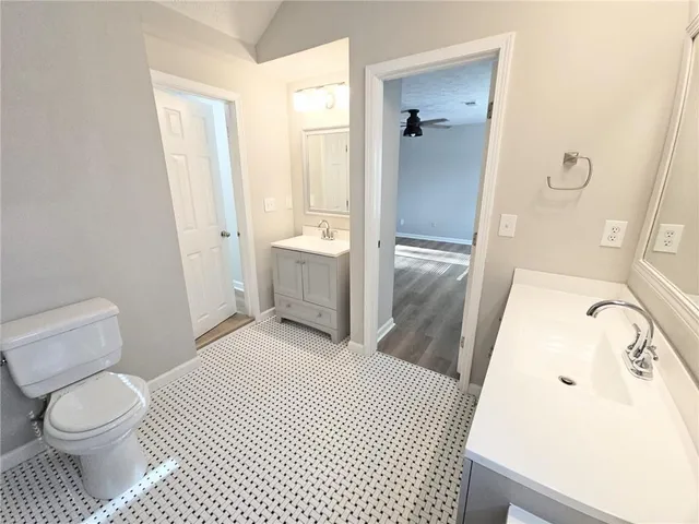 a bathroom with a sink a toilet a window and shower