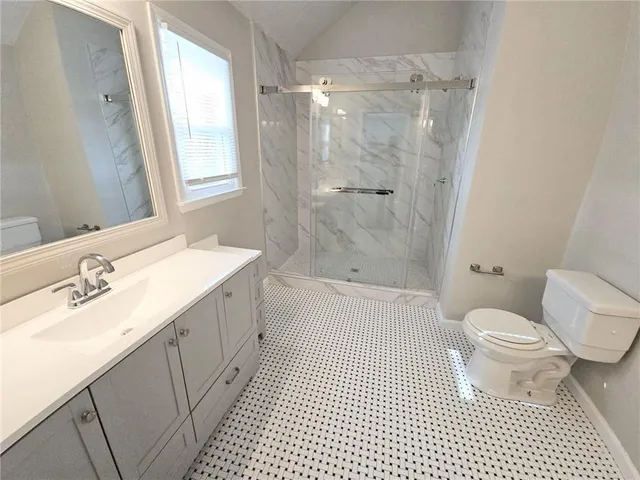a bathroom with a sink a toilet and shower