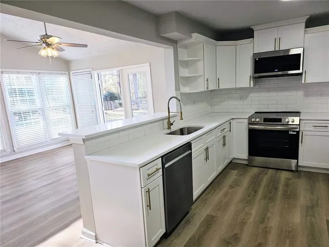 a kitchen with a sink cabinets and wooden floor