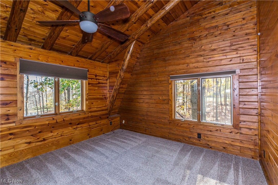 4069 Erhart Road Medina, OH 44256 - Photo 22 of 30 Carpeted spare room with plenty of natural light, lofted ceiling with beams, ceiling fan, and wood ceiling
