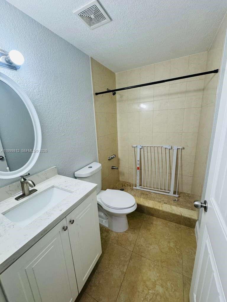 8270 Southwest 149th Court, Unit 10209 Miami, FL 33193 - Photo 26 of 32 a bathroom with a granite countertop sink toilet and a mirror