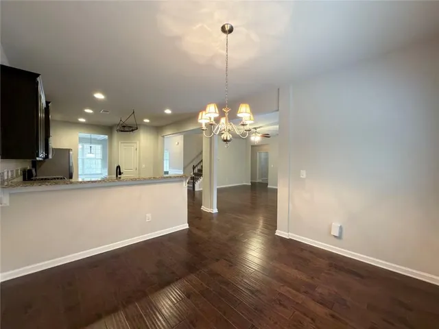 a view of a room with wooden floor and a ceiling fan