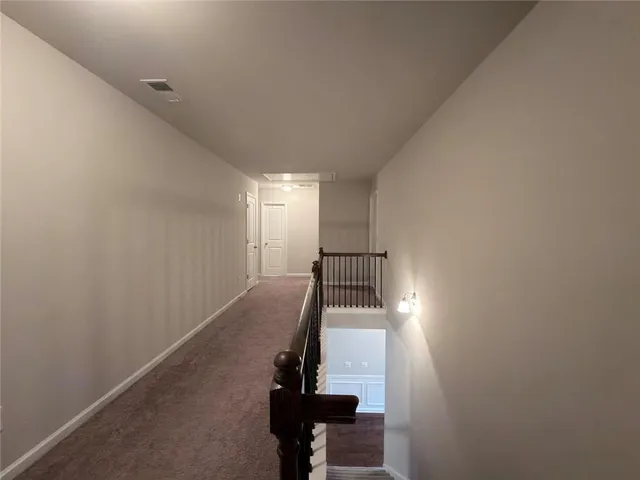a view of an empty room with a chandelier fan