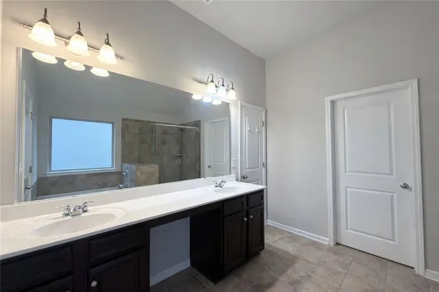 a bathroom with a sink a toilet a mirror and shower