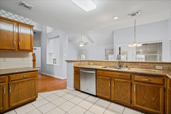 a kitchen with stainless steel appliances granite countertop a sink and dishwasher a stove top oven with wooden floor