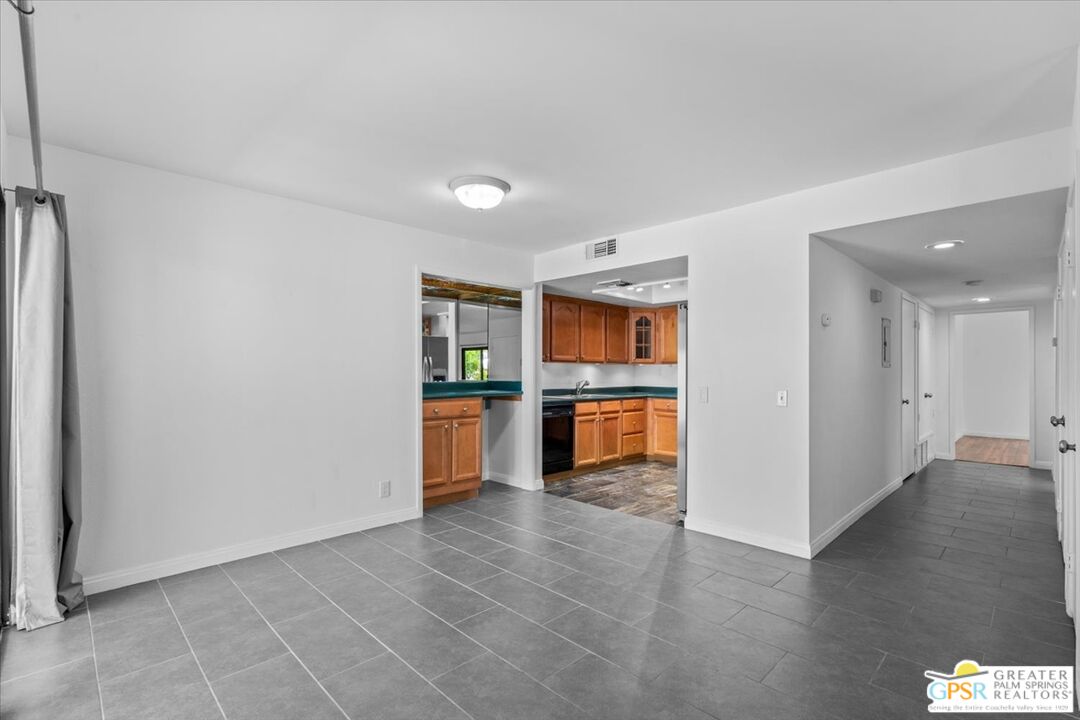 200 East Racquet Club Road, Unit 45 Palm Springs, CA 92262 - Photo 11 of 36 a living room with stainless steel appliances kitchen island granite countertop a refrigerator and a sink