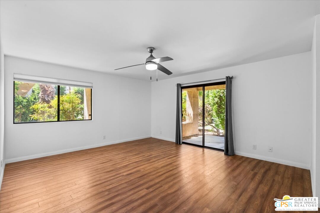 200 East Racquet Club Road, Unit 45 Palm Springs, CA 92262 - Photo 12 of 36 an empty room with wooden floor and windows