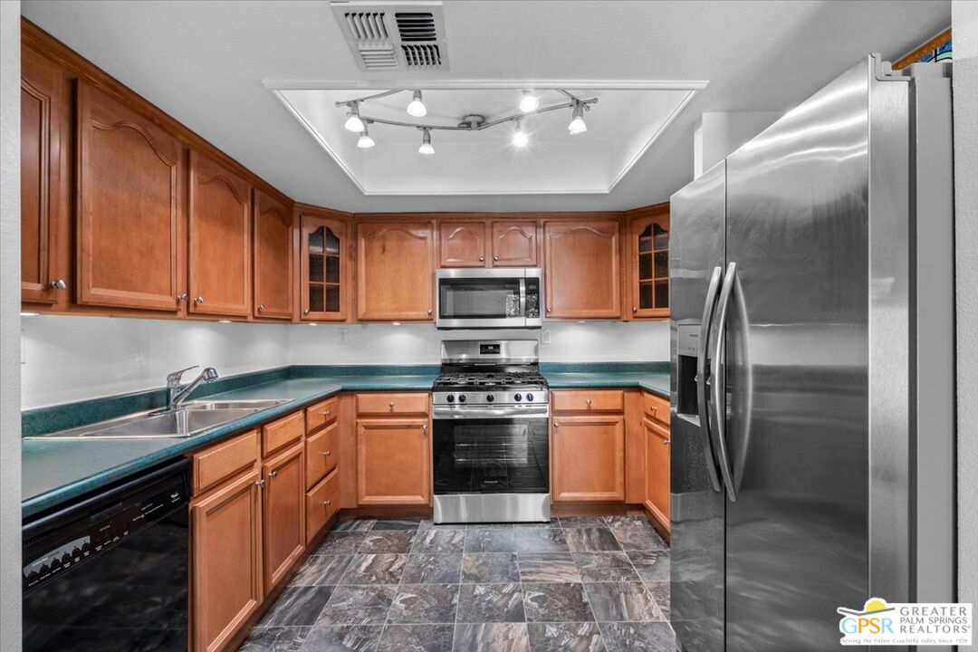 200 East Racquet Club Road, Unit 45 Palm Springs, CA 92262 - Photo 14 of 36 a kitchen with stainless steel appliances granite countertop a stove top oven a sink and dishwasher