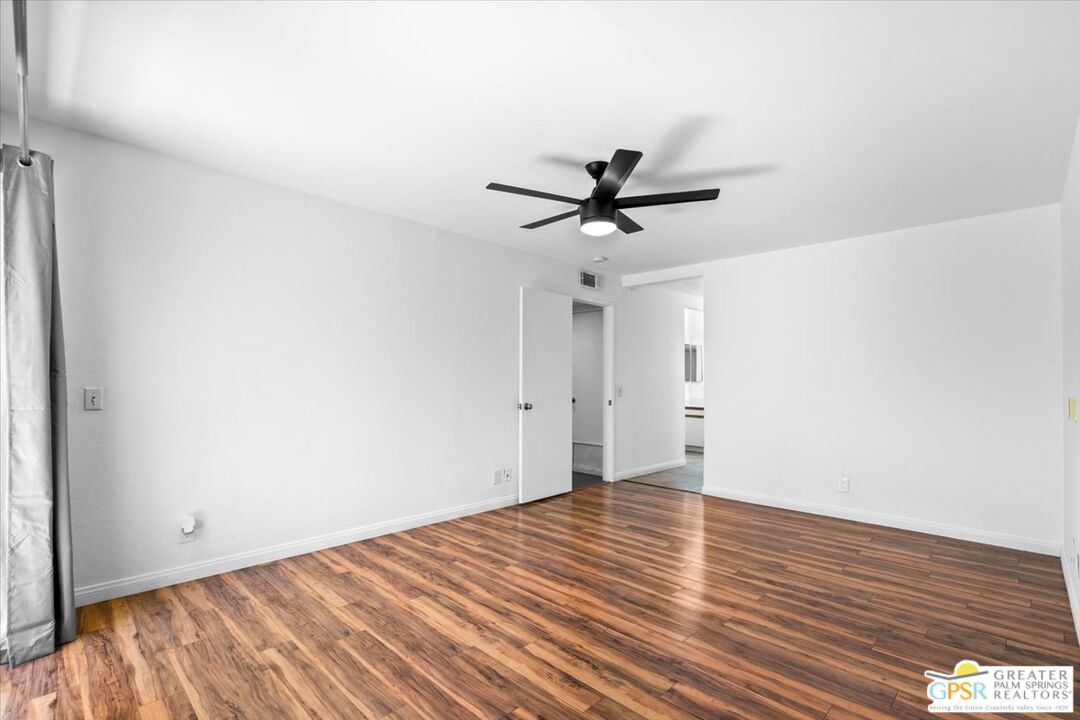 200 East Racquet Club Road, Unit 45 Palm Springs, CA 92262 - Photo 20 of 36 a view of a big room with wooden floor and a ceiling fan
