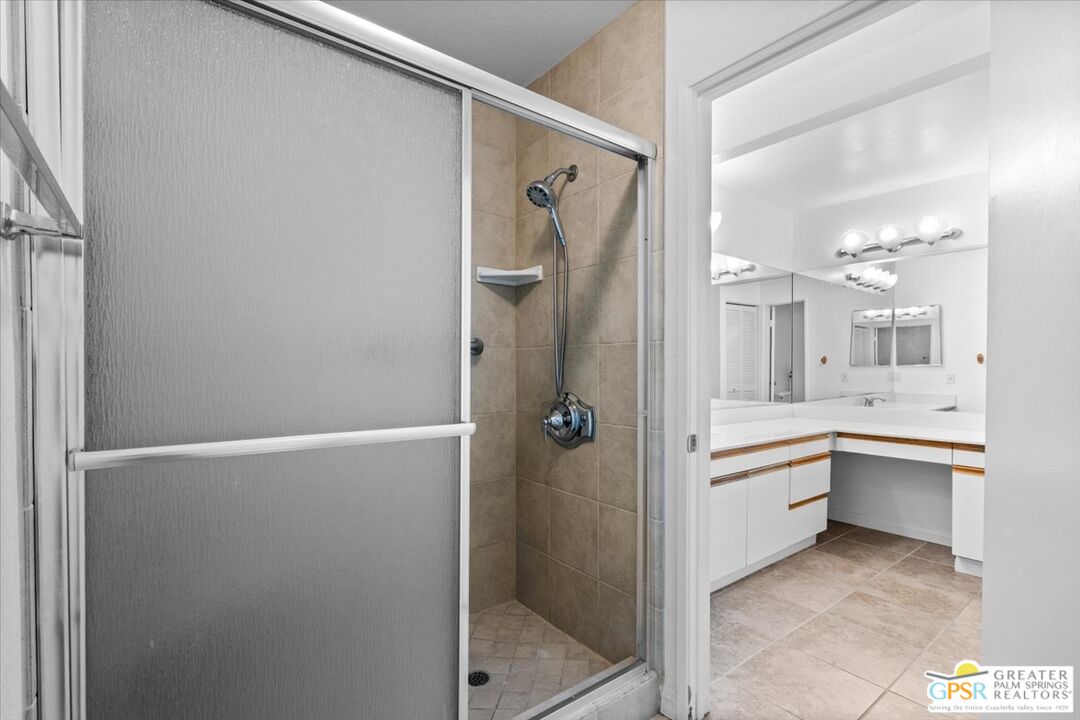 200 East Racquet Club Road, Unit 45 Palm Springs, CA 92262 - Photo 22 of 36 a bathroom with a granite countertop sink mirror and a bathtub