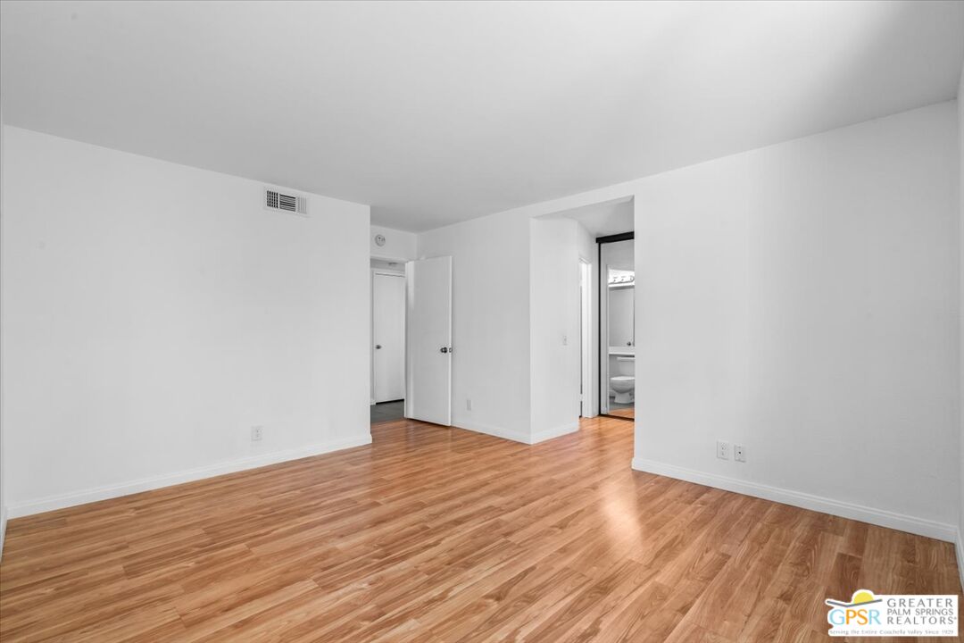 200 East Racquet Club Road, Unit 45 Palm Springs, CA 92262 - Photo 25 of 36 a view of an empty room with wooden floor and a window
