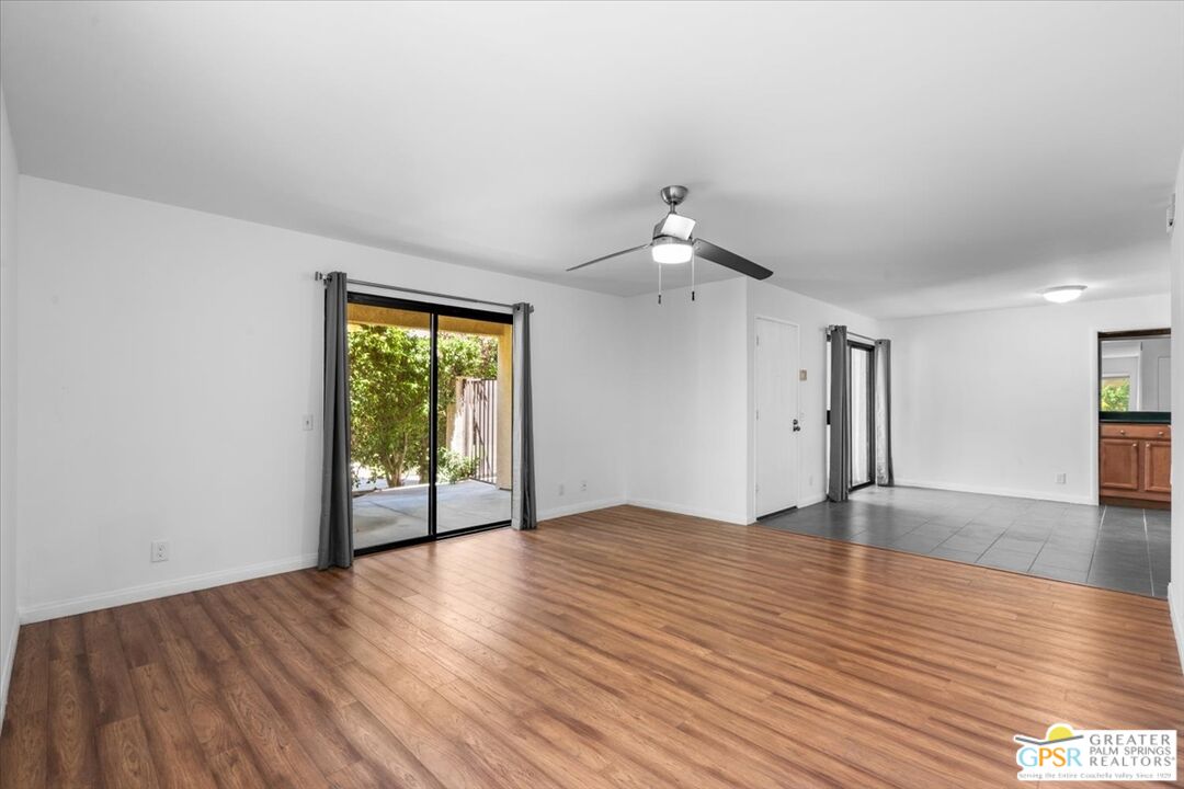 200 East Racquet Club Road, Unit 45 Palm Springs, CA 92262 - Photo 5 of 36 a view of an empty room with wooden floor and a window