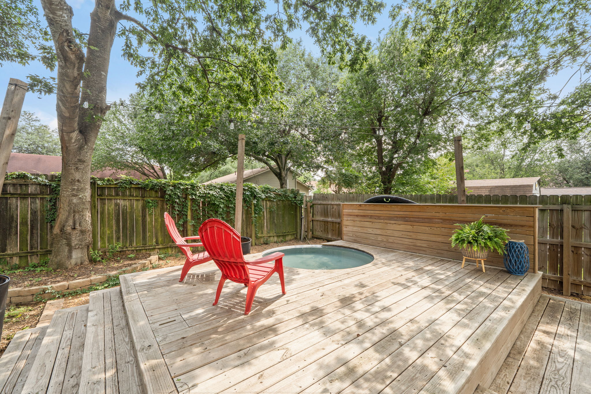 705 Dulwich Street Austin, TX 78748 - Photo 29 of 36 A well-appointed wood deck offers a private hot tub, perfect for unwinding amidst lush greenery.