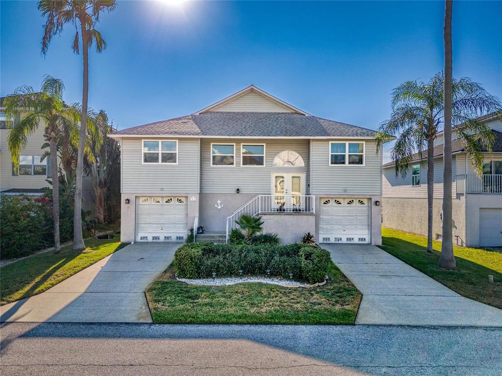 a front view of a house with a yard and potted plants