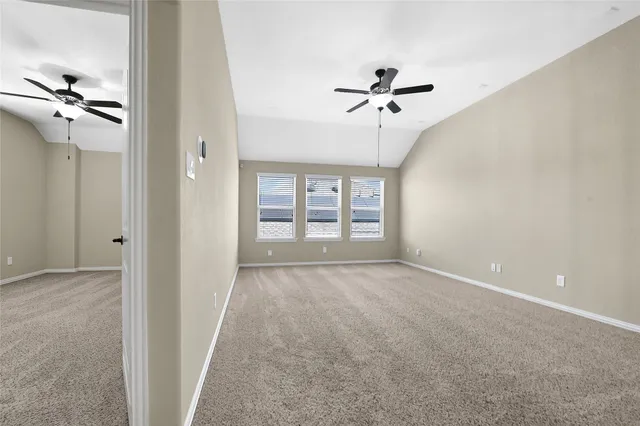 a view of a big room with windows and chandelier fan