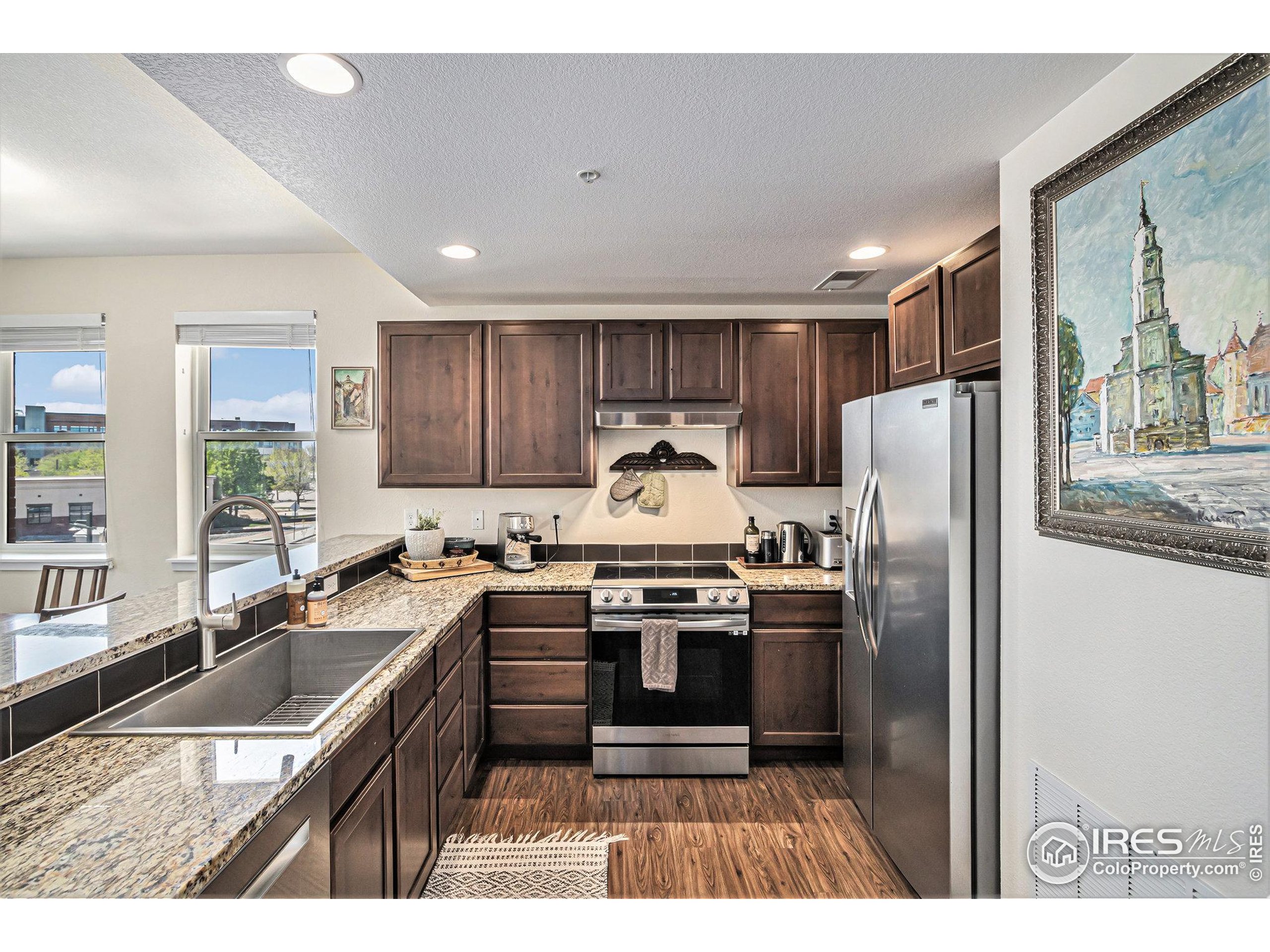 220 Willow Street, Unit 301 Fort Collins, CO 80524 - Photo 5 of 27 a kitchen with stainless steel appliances granite countertop a sink stove and refrigerator