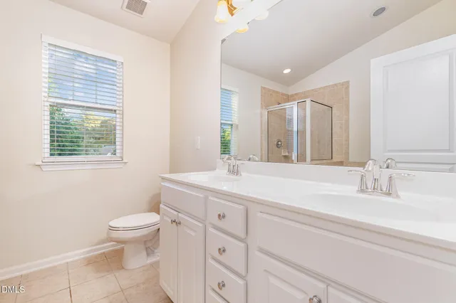 a bathroom with a granite countertop sink mirror vanity and a toilet