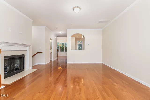 a view of empty room with wooden floor and fireplace