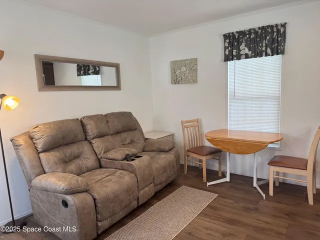 a living room with furniture a window and a chair