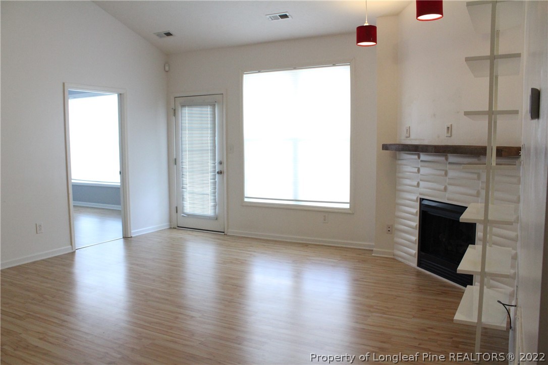 1324 Kershaw Loop, Unit 206 Fayetteville, NC 28314 - Photo 14 of 18 a view of an empty room with wooden floor and a window