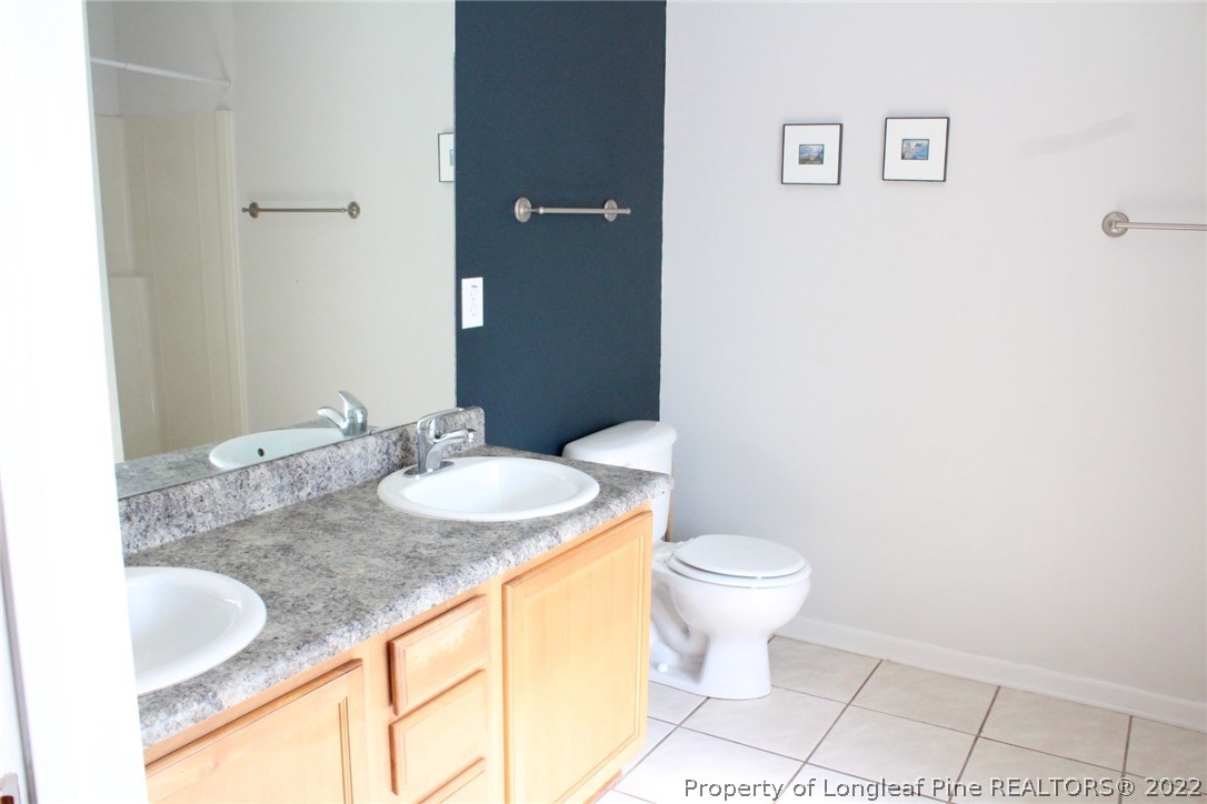 1324 Kershaw Loop, Unit 206 Fayetteville, NC 28314 - Photo 5 of 18 a bathroom with a granite countertop sink and a mirror