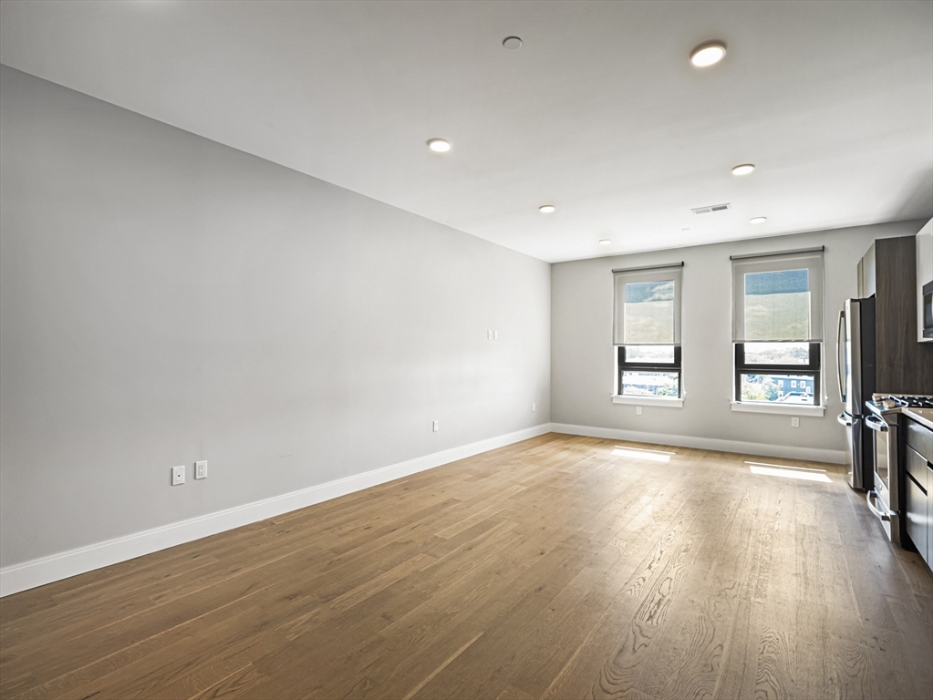 9 Central Street, Unit 405 Somerville, MA 02143 - Photo 8 of 24 an empty room with wooden floor and windows