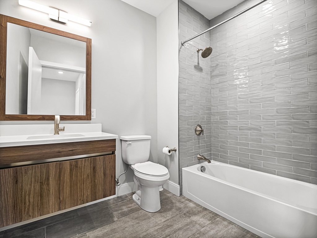 9 Central Street, Unit 405 Somerville, MA 02143 - Photo 10 of 24 a bathroom with a sink a toilet and a bathtub