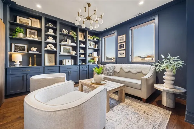 a living room with furniture a bookshelf and a window