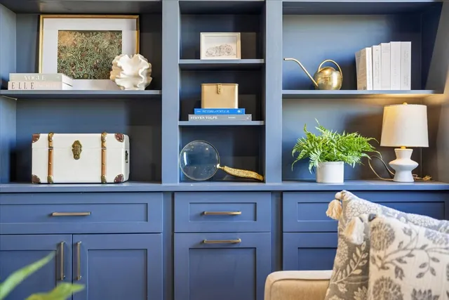a living room with wooden floor and a potted plant